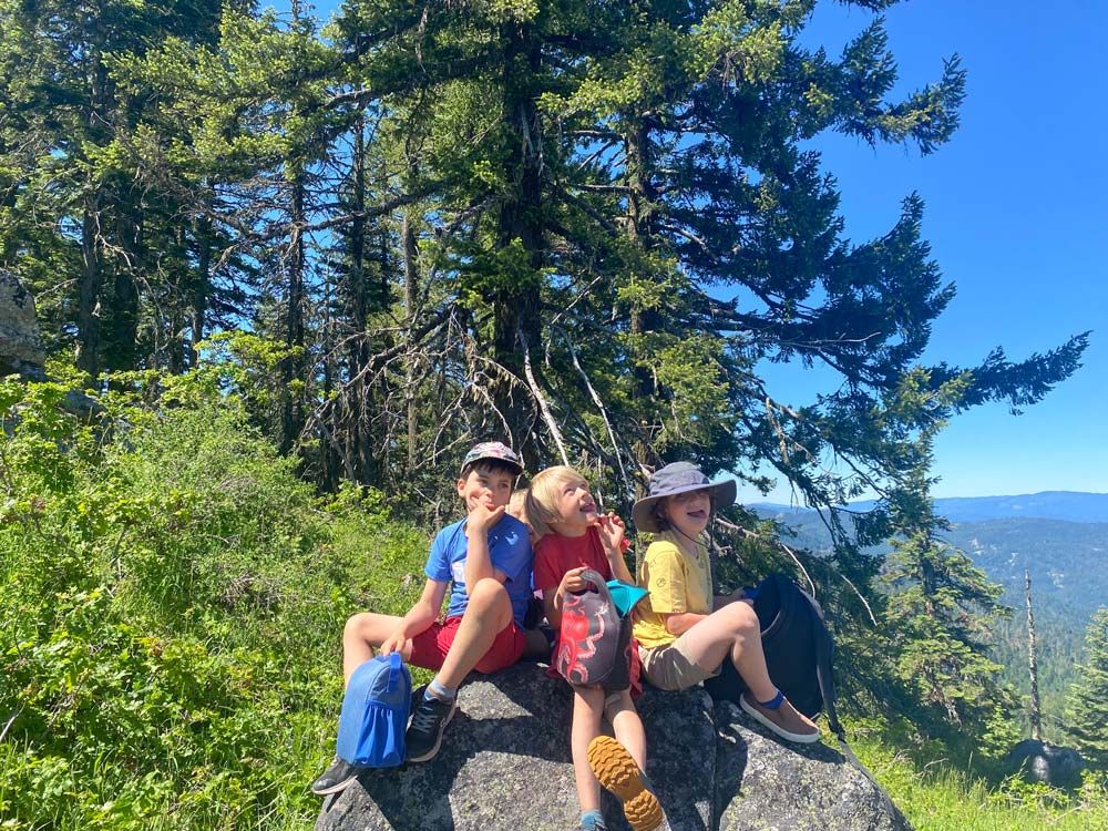The Crest nature day campers enjoying summer sunshine on a boulder