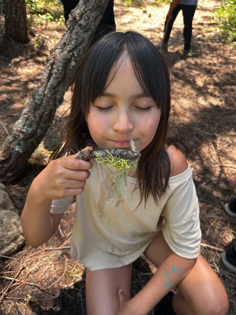 Nature Day Camper enjoys the smell of fresh lichen on a branch