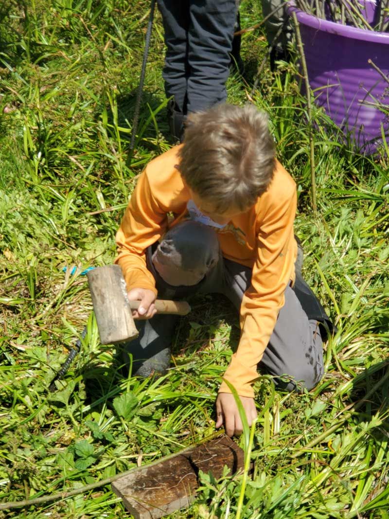 Nature Day Camp participant prepares willows before planting