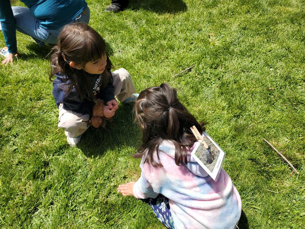 two young girls sitting on grass during field trip to The Crest at Willow-Witt Ranch