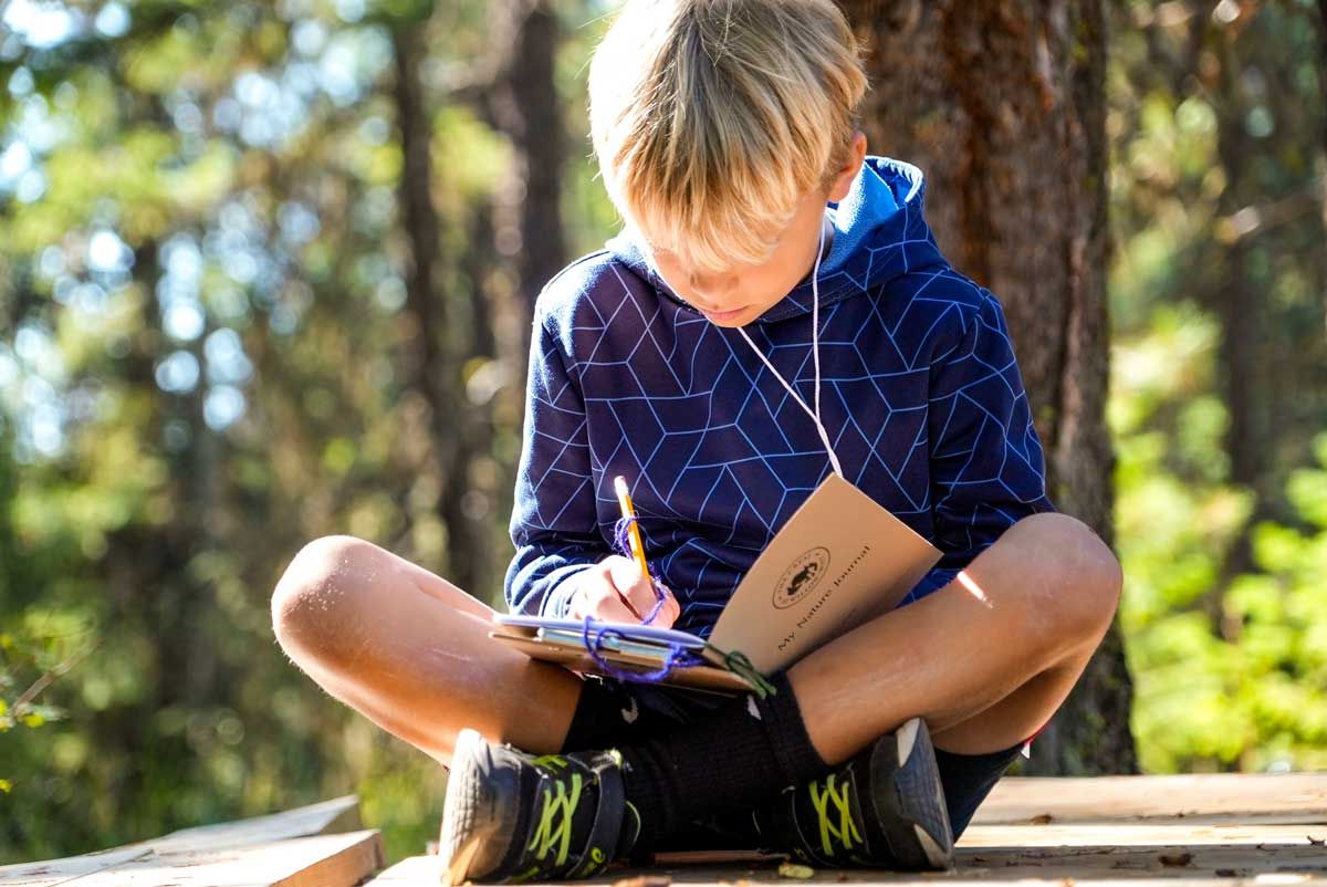 young student writes in journal during full day field trip to The Crest at Willow-Witt Ranch
