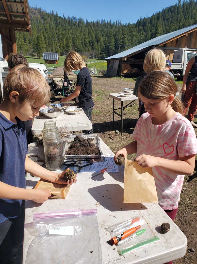 Nature Day Camp students working on a project at tables outdoors