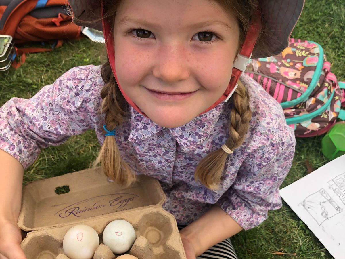 smiling summer camp child gathering eggs