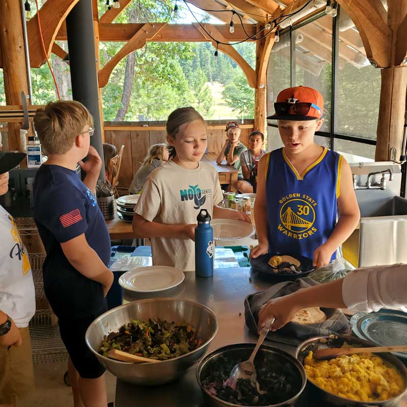 students gather to fill plates with fresh scrambled eggs and garden greens