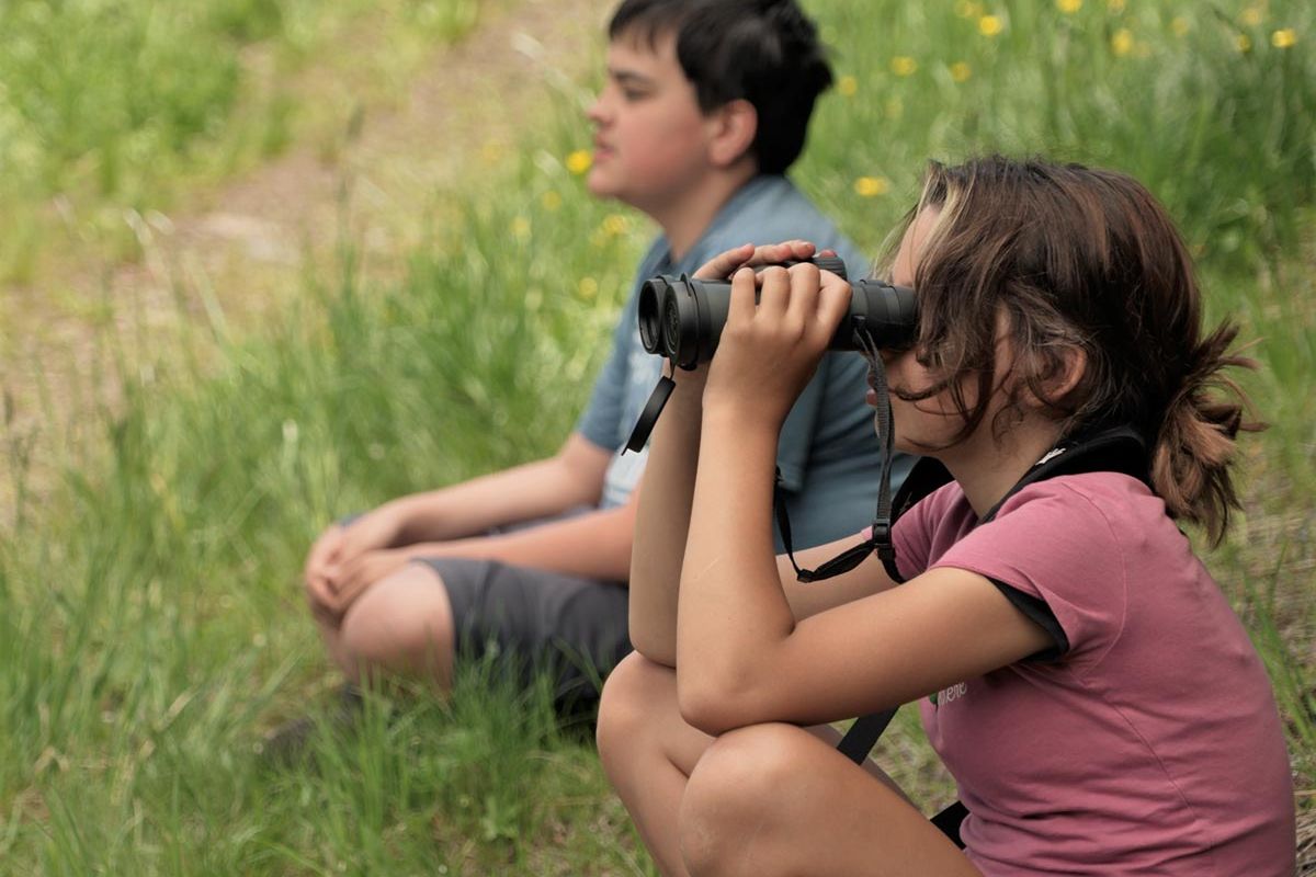 outdoor school students using binoculars in the field