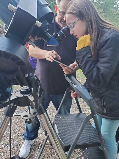 young woman getting telescope lesson during Star Party